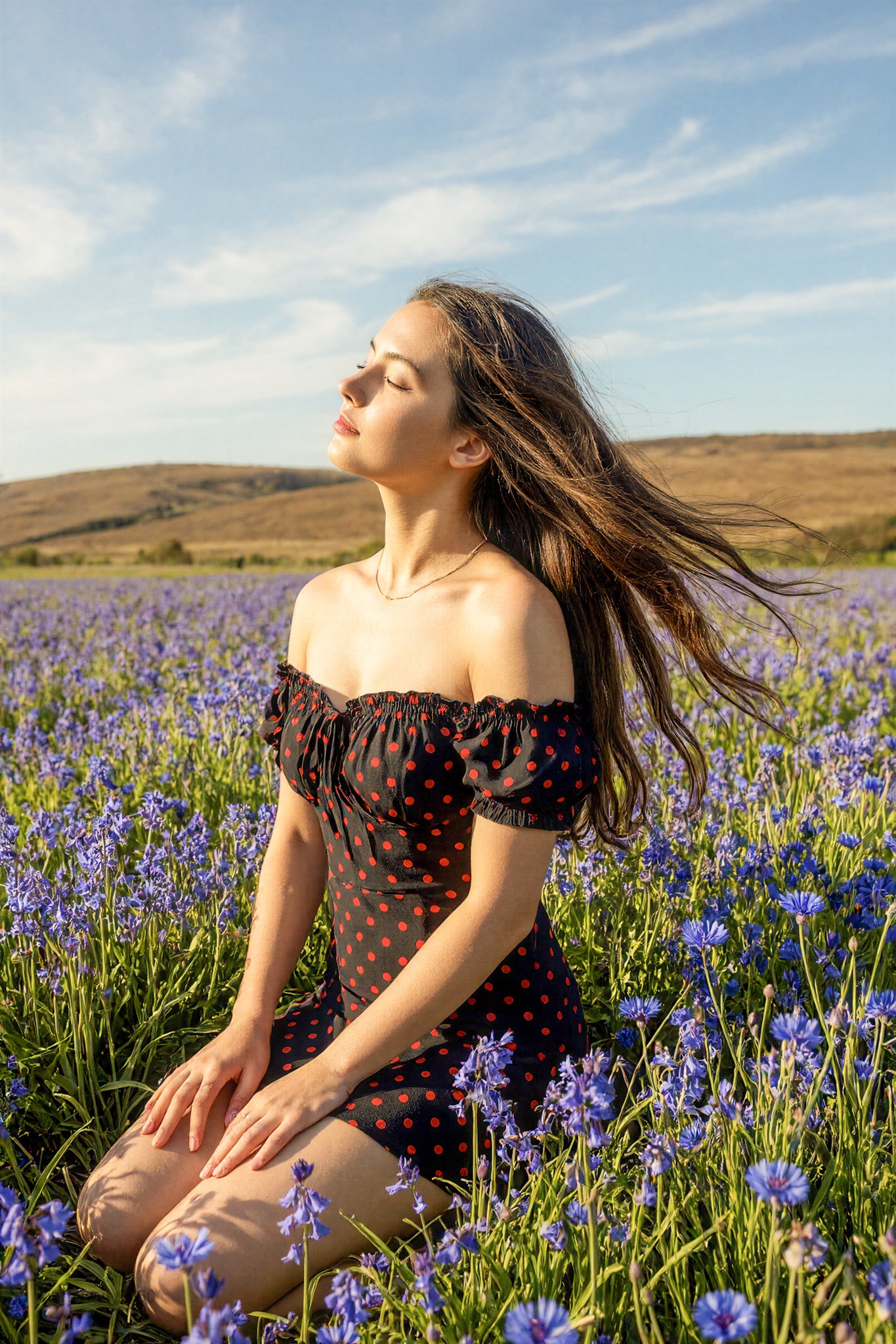 Young Woman Kneeling in Wildflower Field